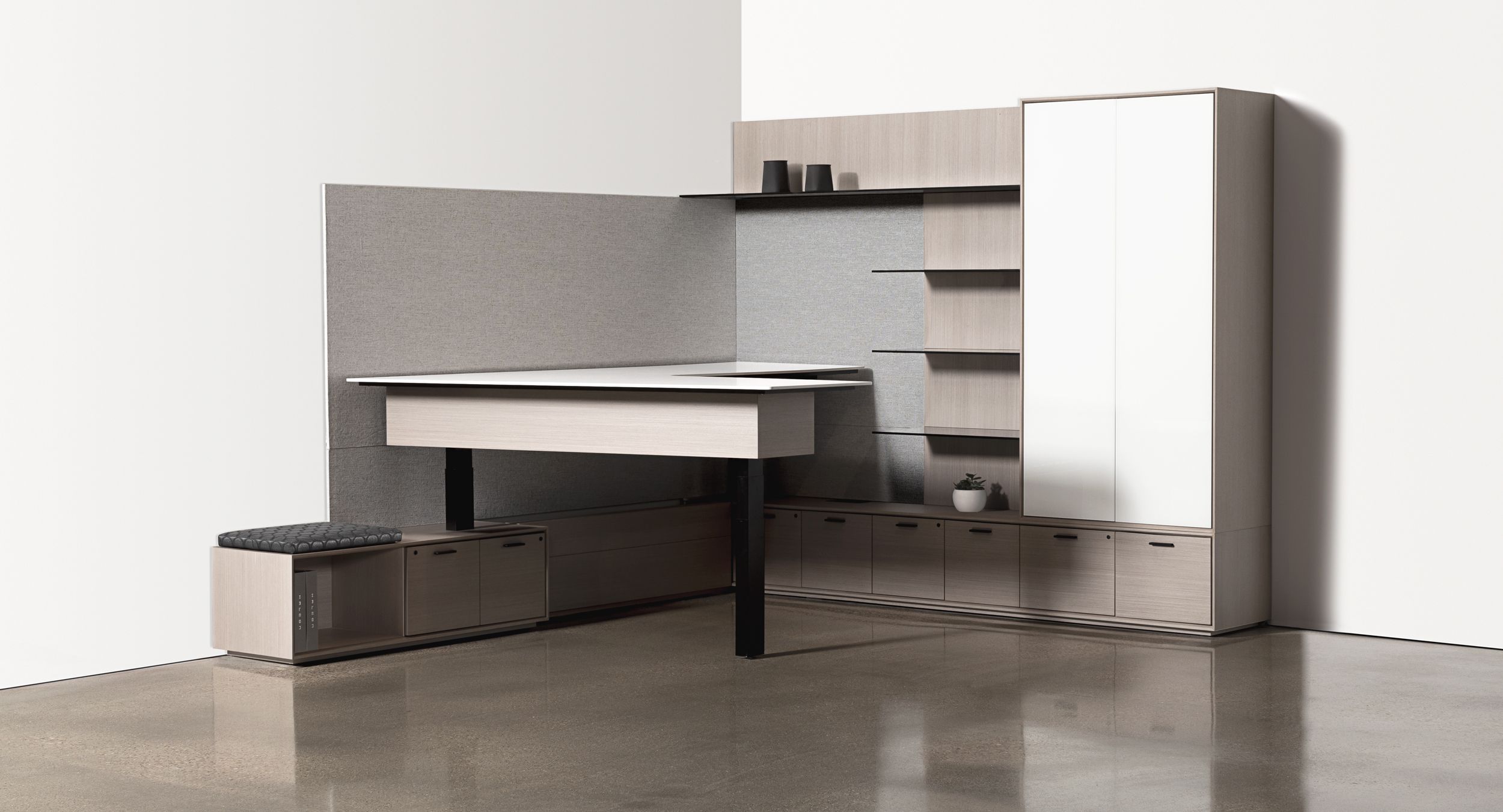 Custom private office with L-shaped adjustable-height work surface, and integrated guest seating.