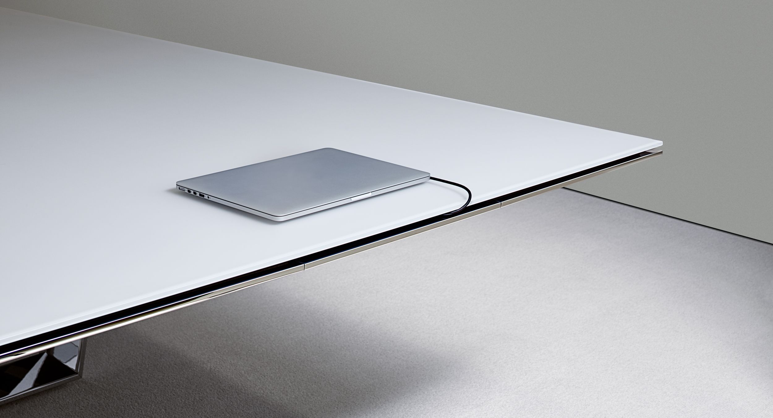 Cables exit gracefully from a continuous edge reveal above the concealed drawer, eliminating the typical mess of wires. 