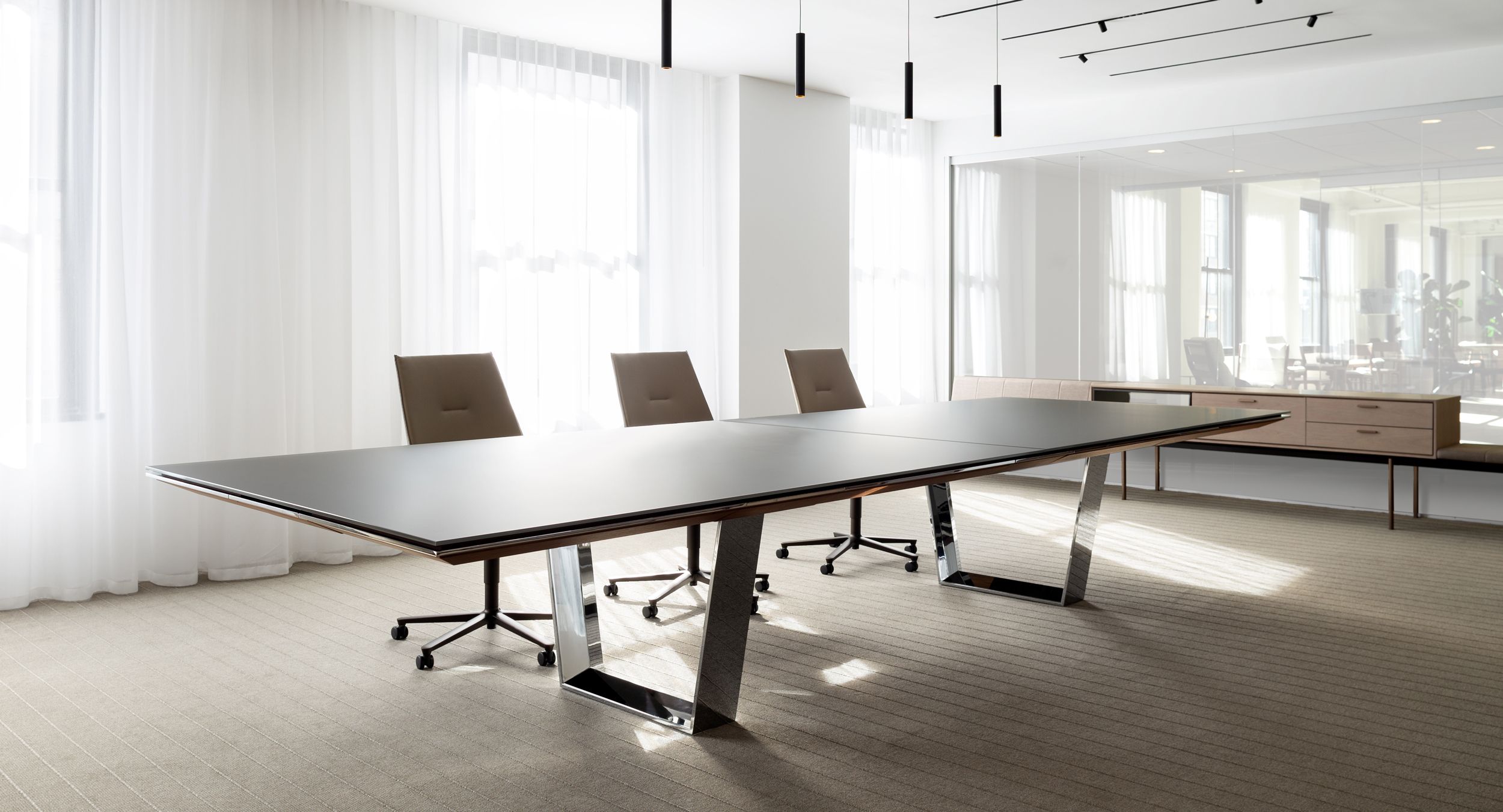 A MESA conference table with etched back-painted glass and polished chrome is the centerpiece of this airy conference room.