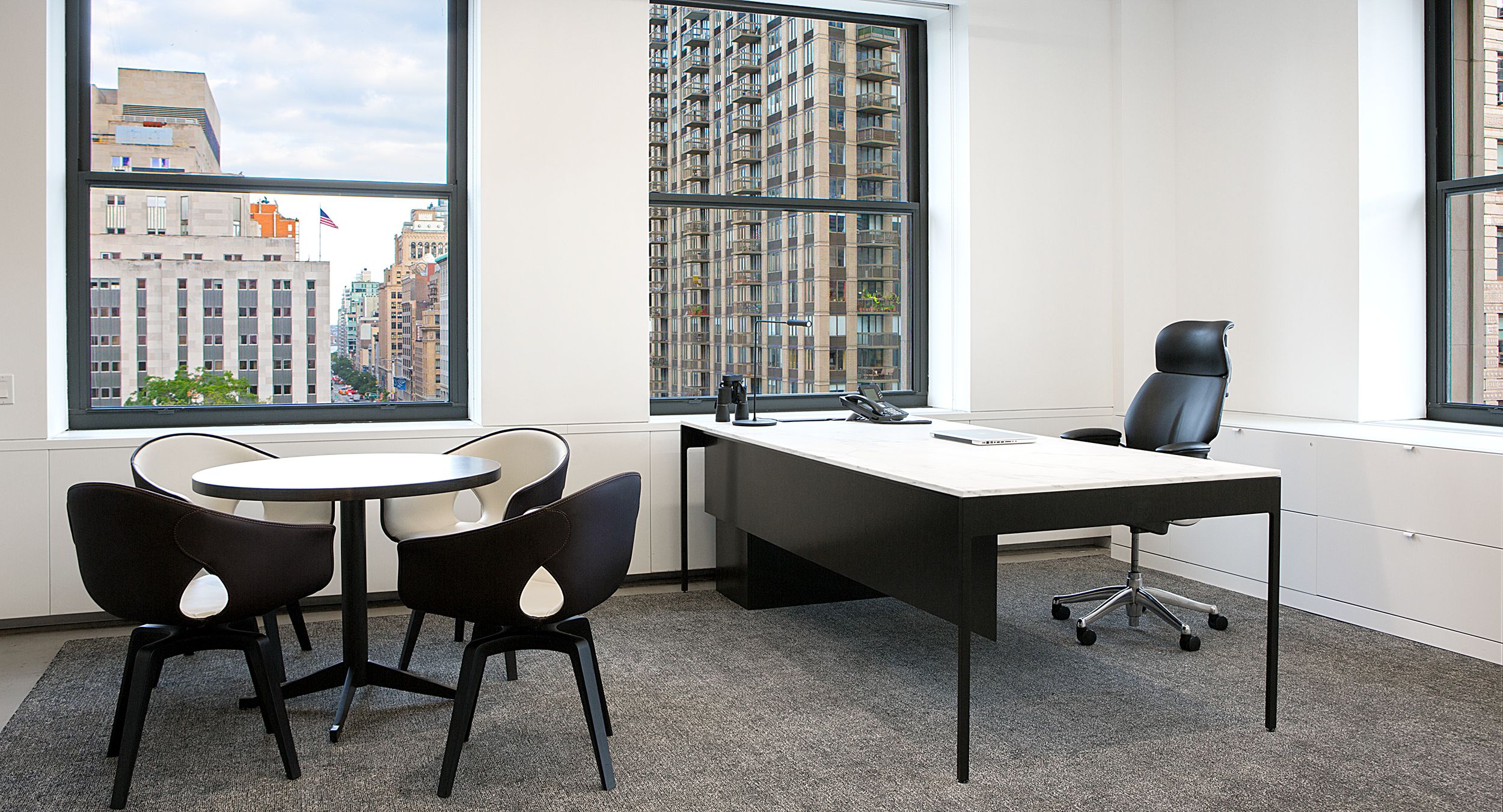 Private offices feature White Corian and glass paired with bronze table legs.