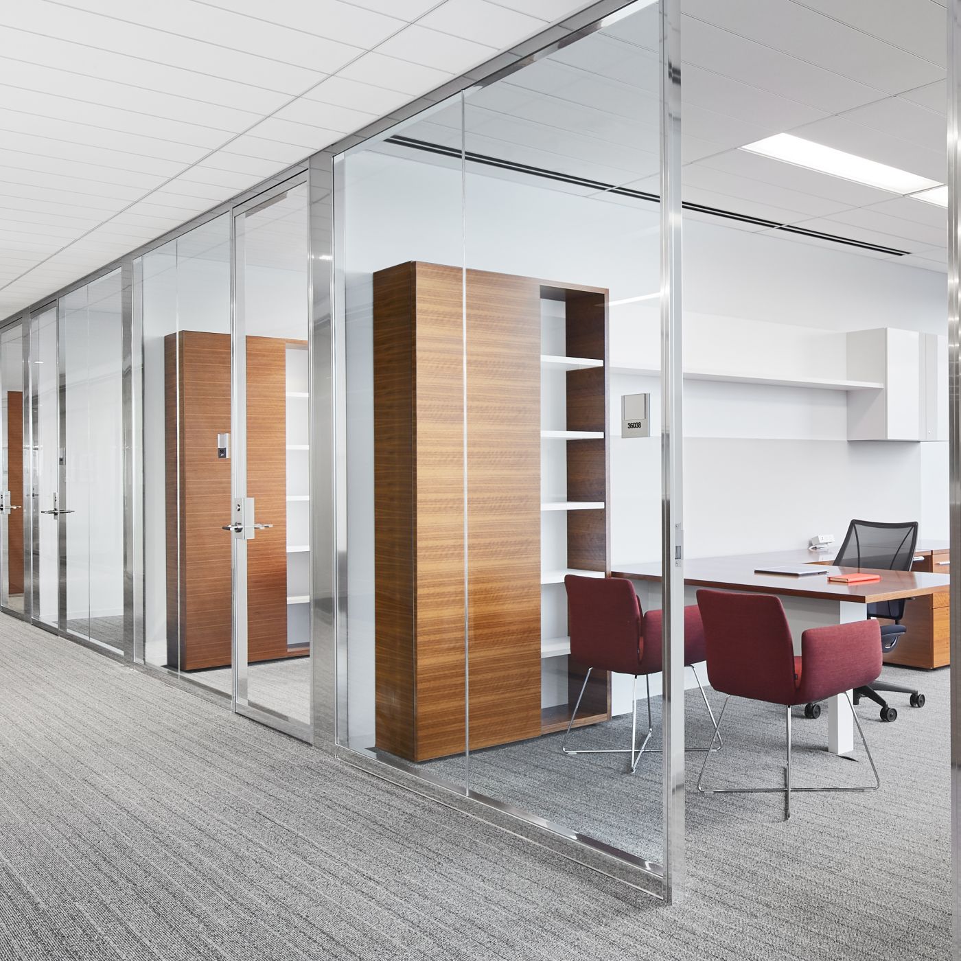 NEW MILLENNIA private offices feature a mix of open and closed storage in grain-matched Quarter Cut Walnut and White.