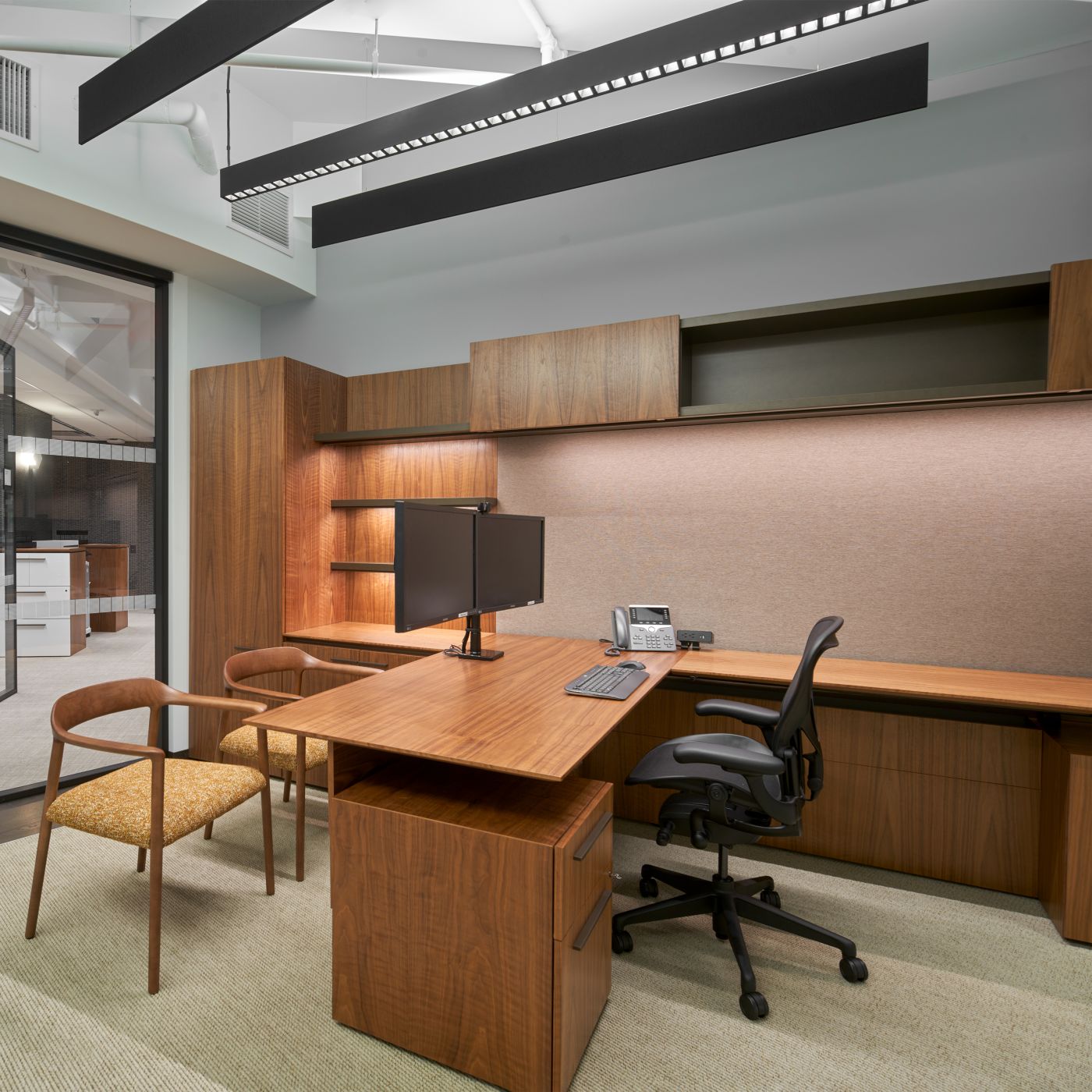 Custom Private Office with adjustable-height surface in Flat Cut Figured Walnut, Bronze Metallic, and LUUM Percept tack panel.