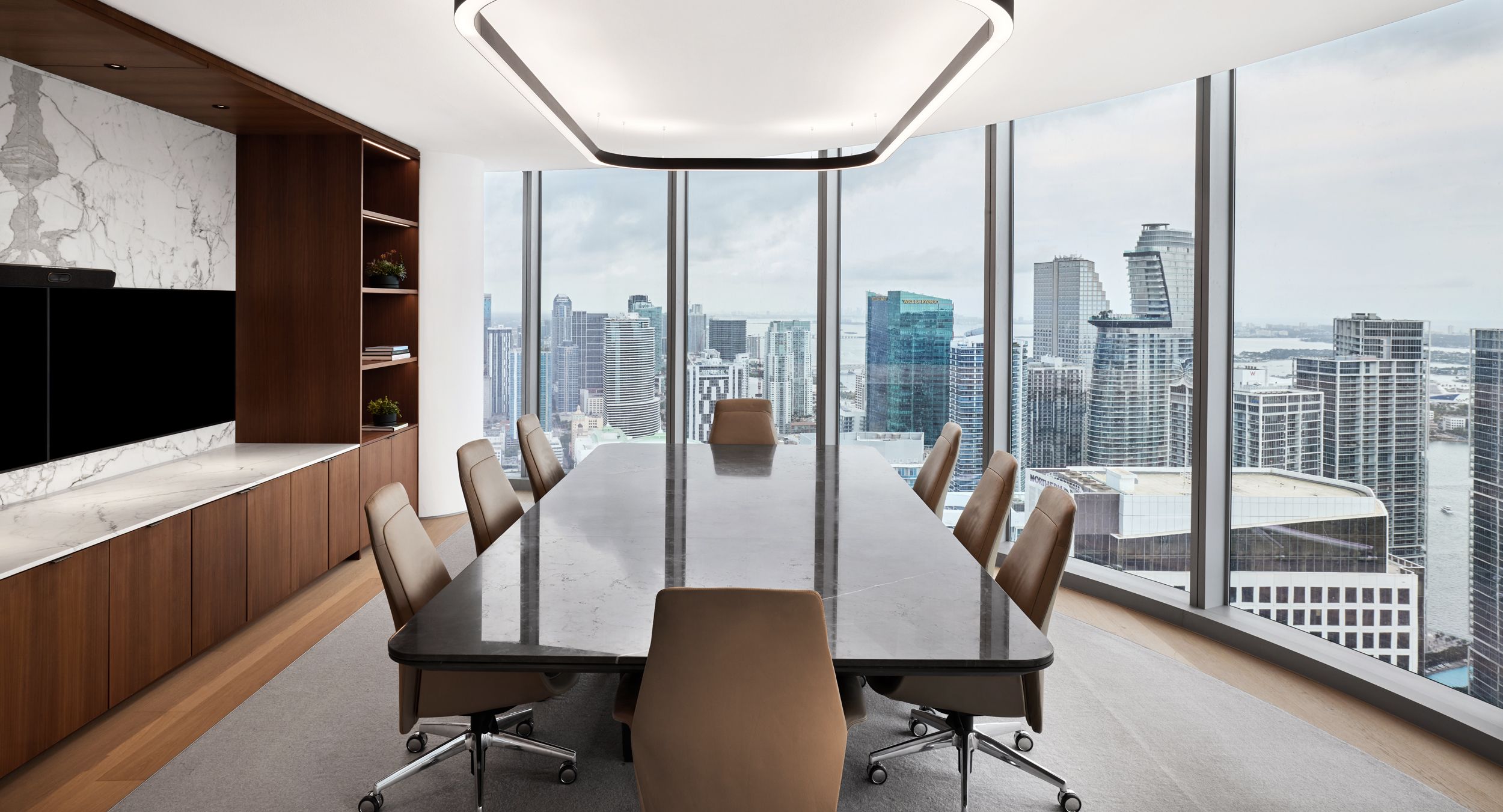 A custom HALO / OPTIC conference table is the centerpiece for this executive meeting space.