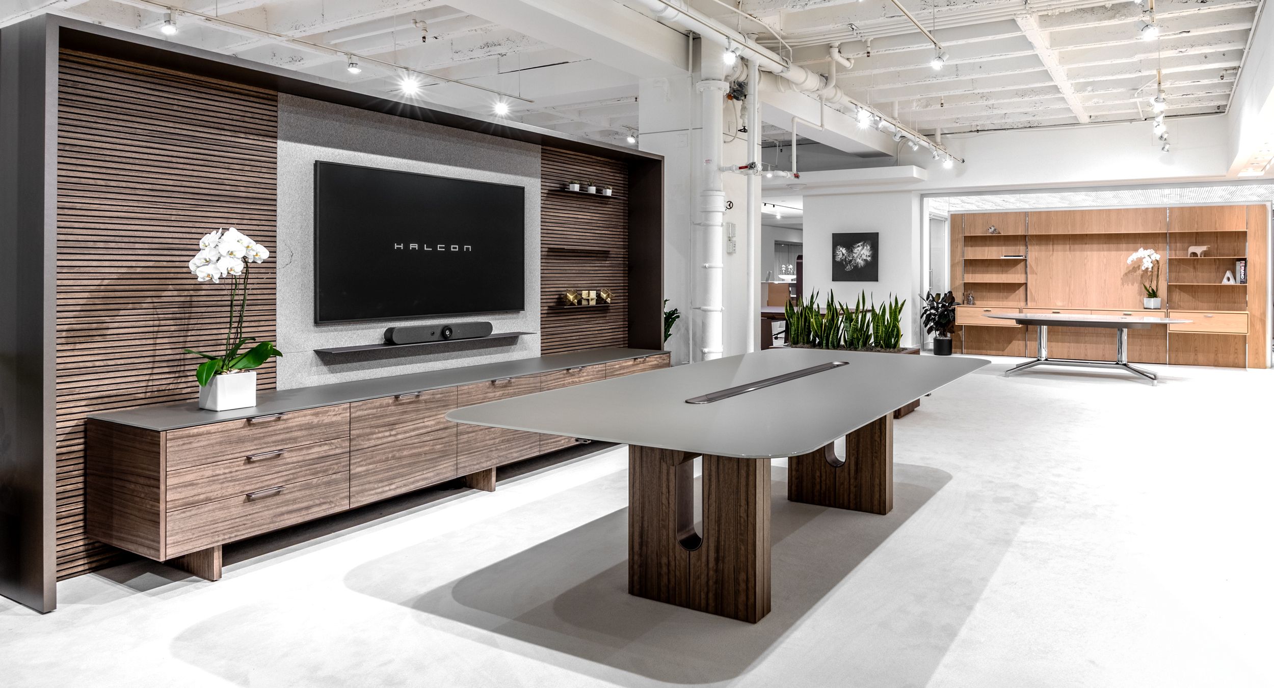 FREYA conference table with linear power bay, back-wall, and credenza in custom figured Paldao and Light Bronze.
