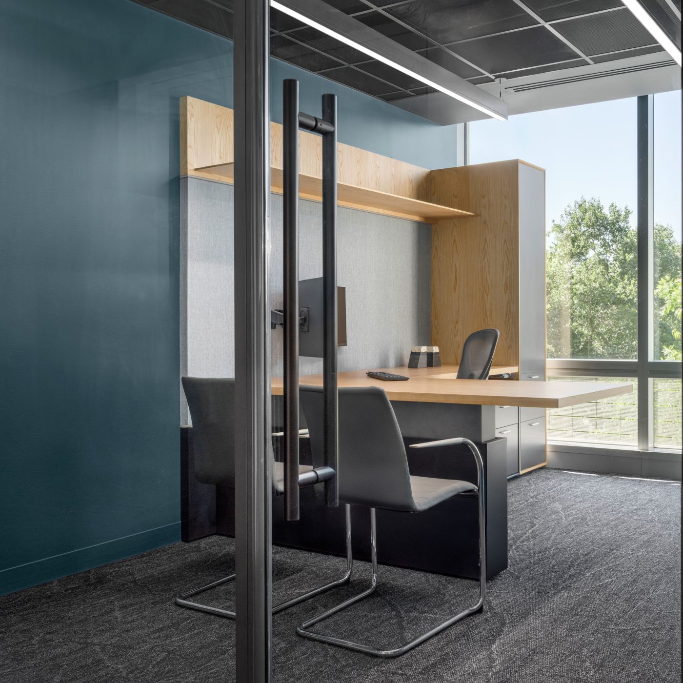 Custom private office with an L-shaped adjustable-height worksurface.