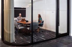 A small conference room with a 42d x 108w HALO continuous base conference table in Natural Flat Cut Walnut. thumbnail