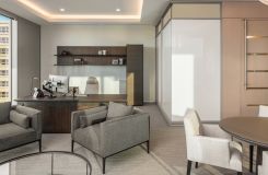 L-shaped adjustable-height HALO private office in smoked walnut with light bronze pulls. thumbnail