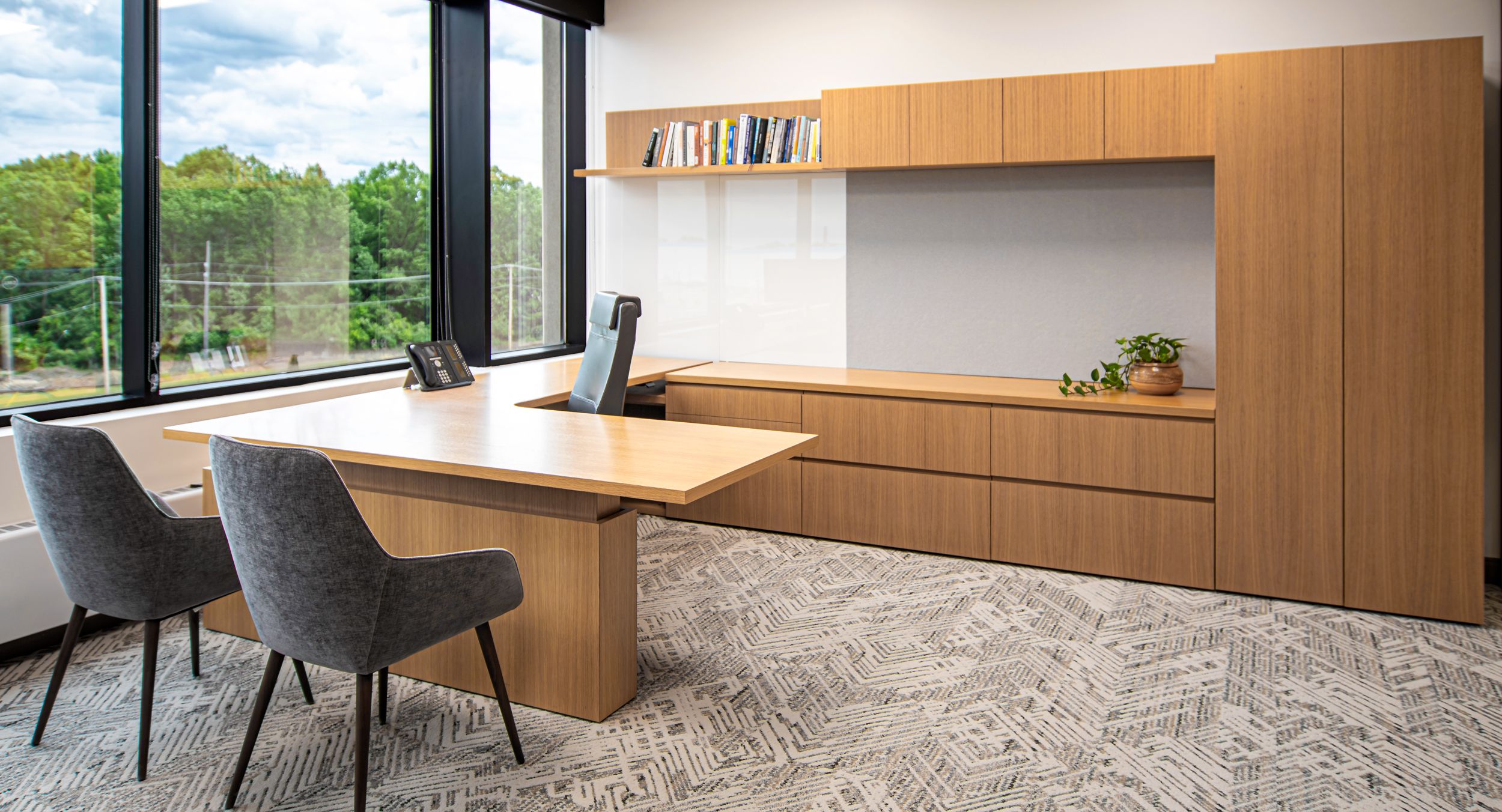 New Millennia Private Office in White Oak with Designer White back-painted glass tack panel and adjustable height worksurface.