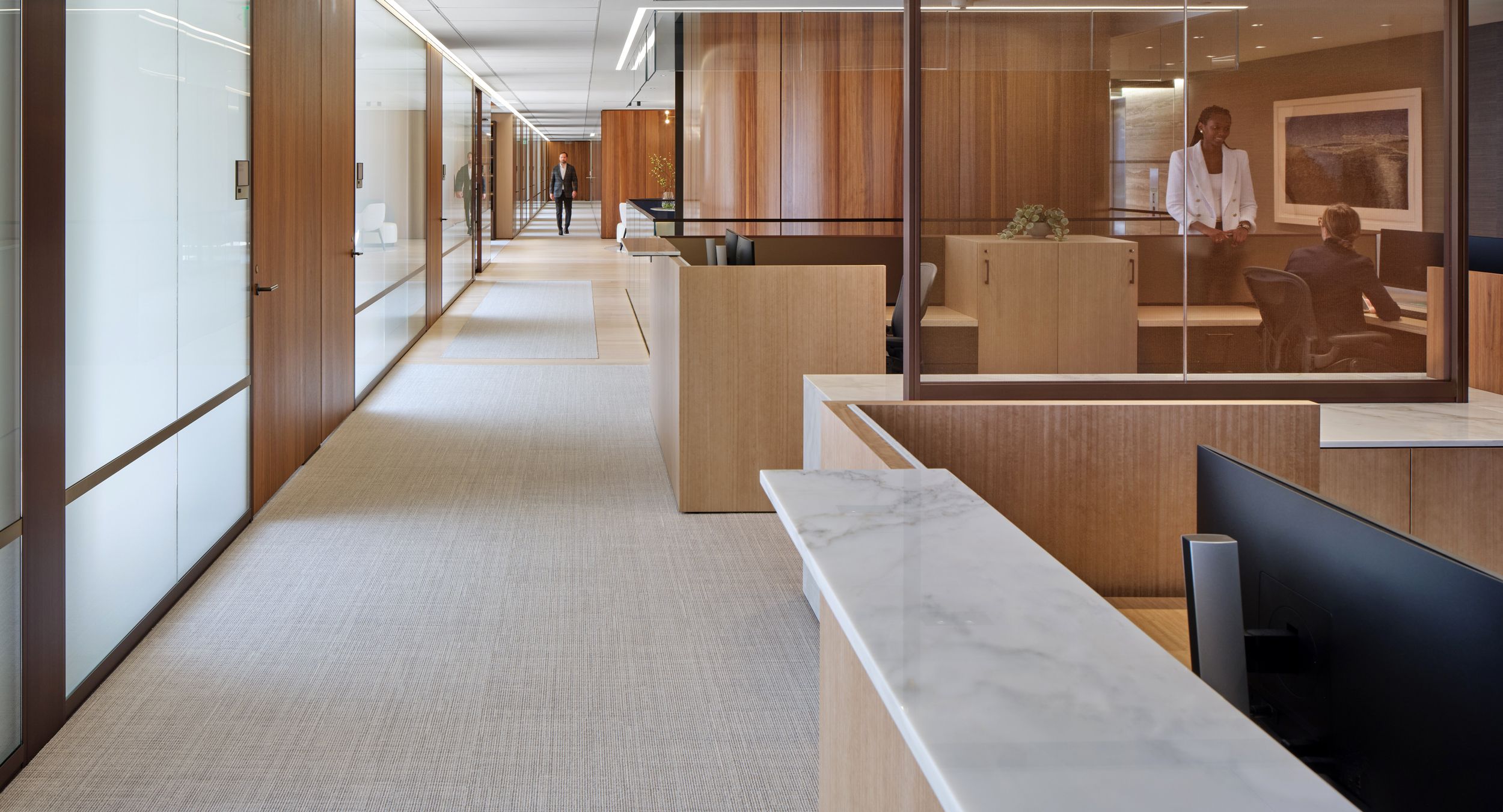 Custom New Millennia 2-seat workstation in Natural Figured Eucalyptus with Calacatta Sponda transaction surfaces.