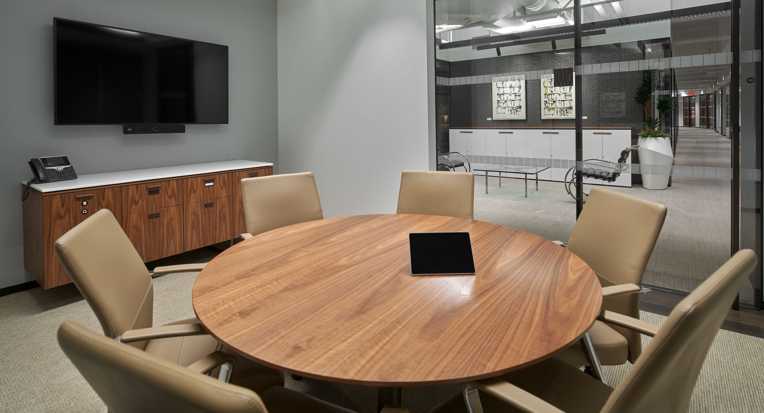 Round Stratos conference table complemented by a custom credenza in Figured Walnut and Deep Bronze.