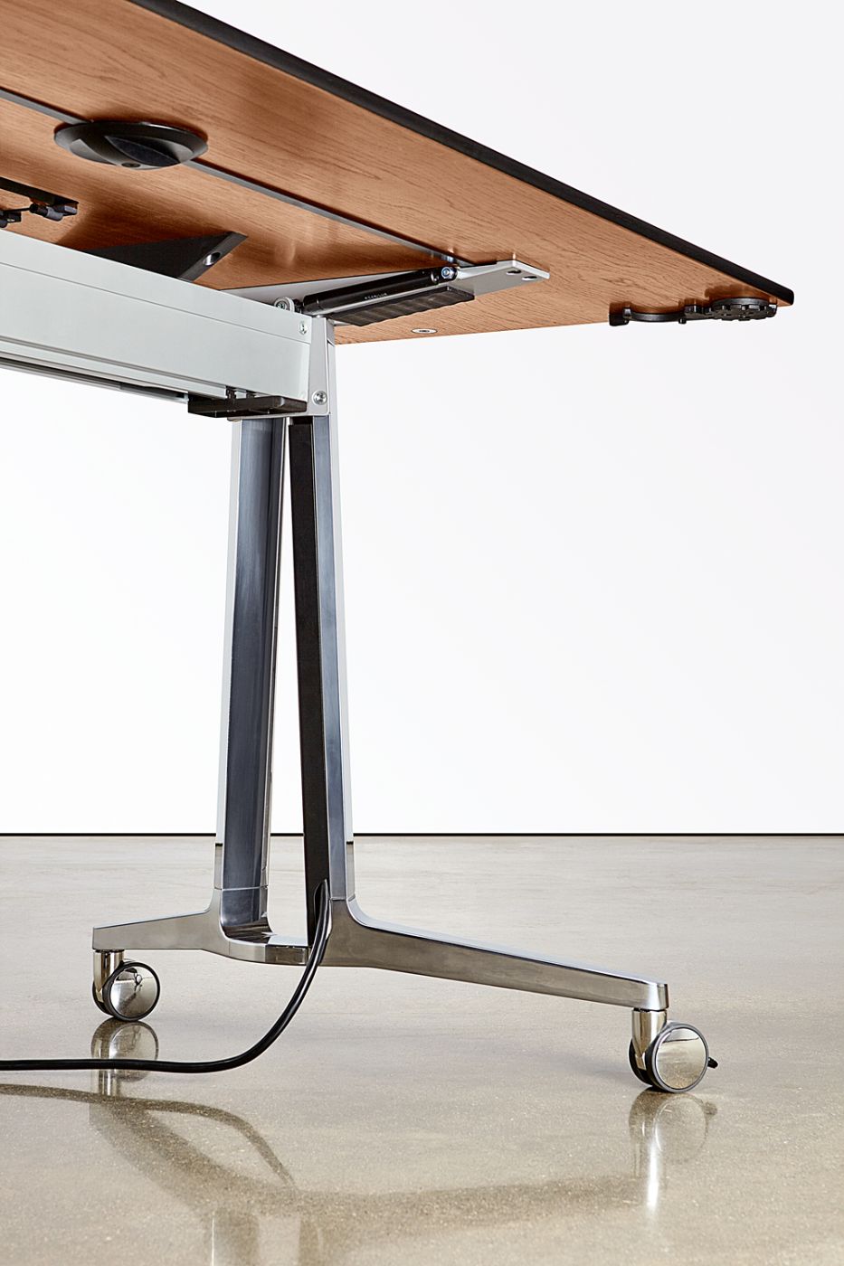 A minimalist leg wire chase hides cables for powered mobile tables.