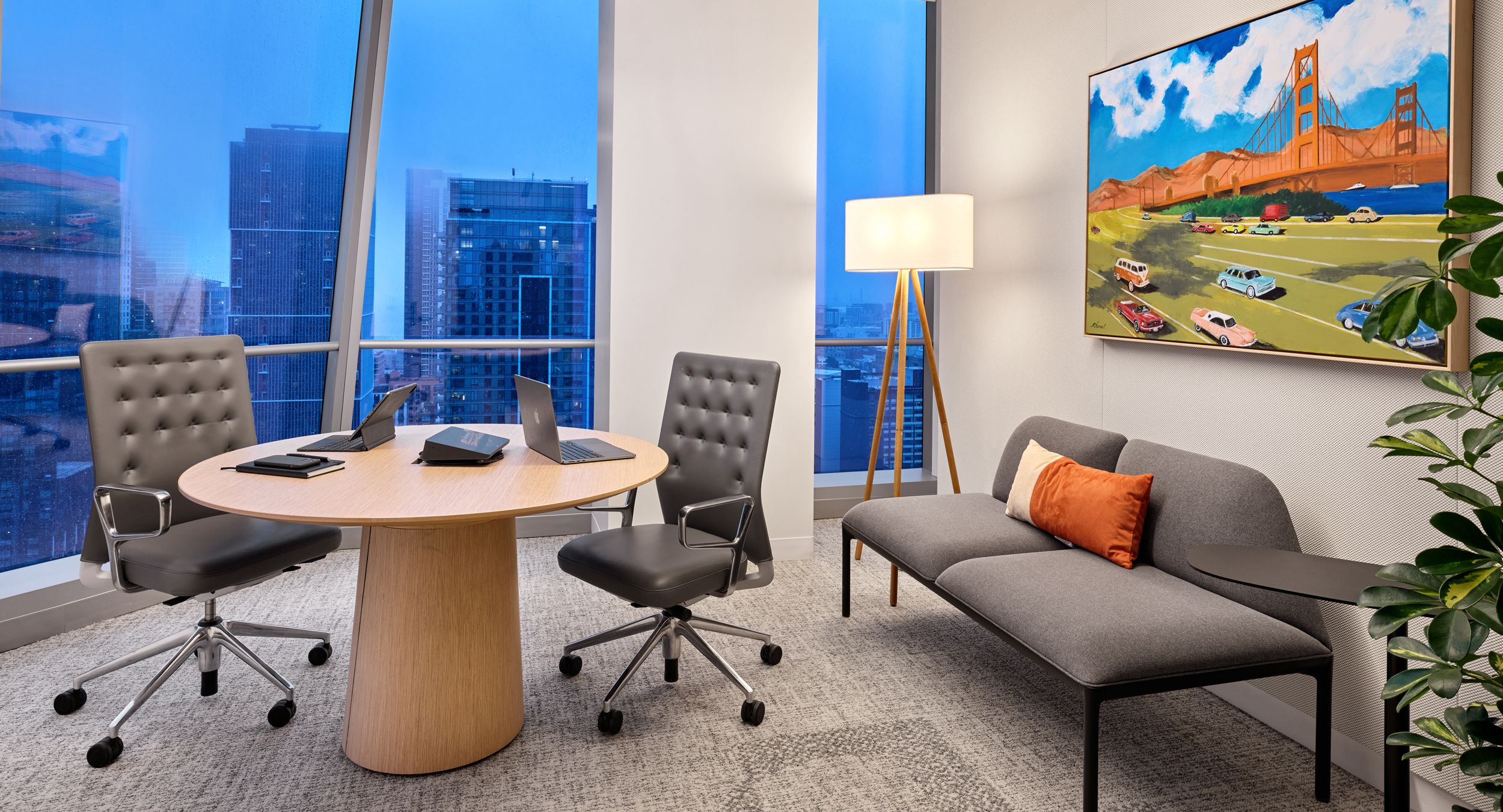 A small breakout room is centered by a round SESSIONS table in white Oak.