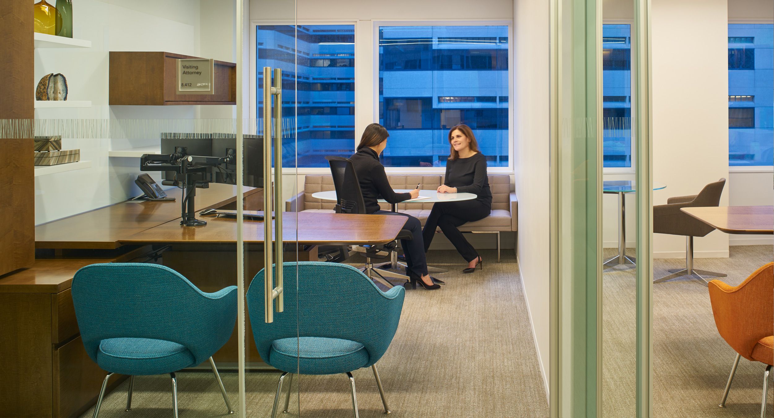 Universal attorney offices feature adjustable-height desking and a comfortable meeting space.