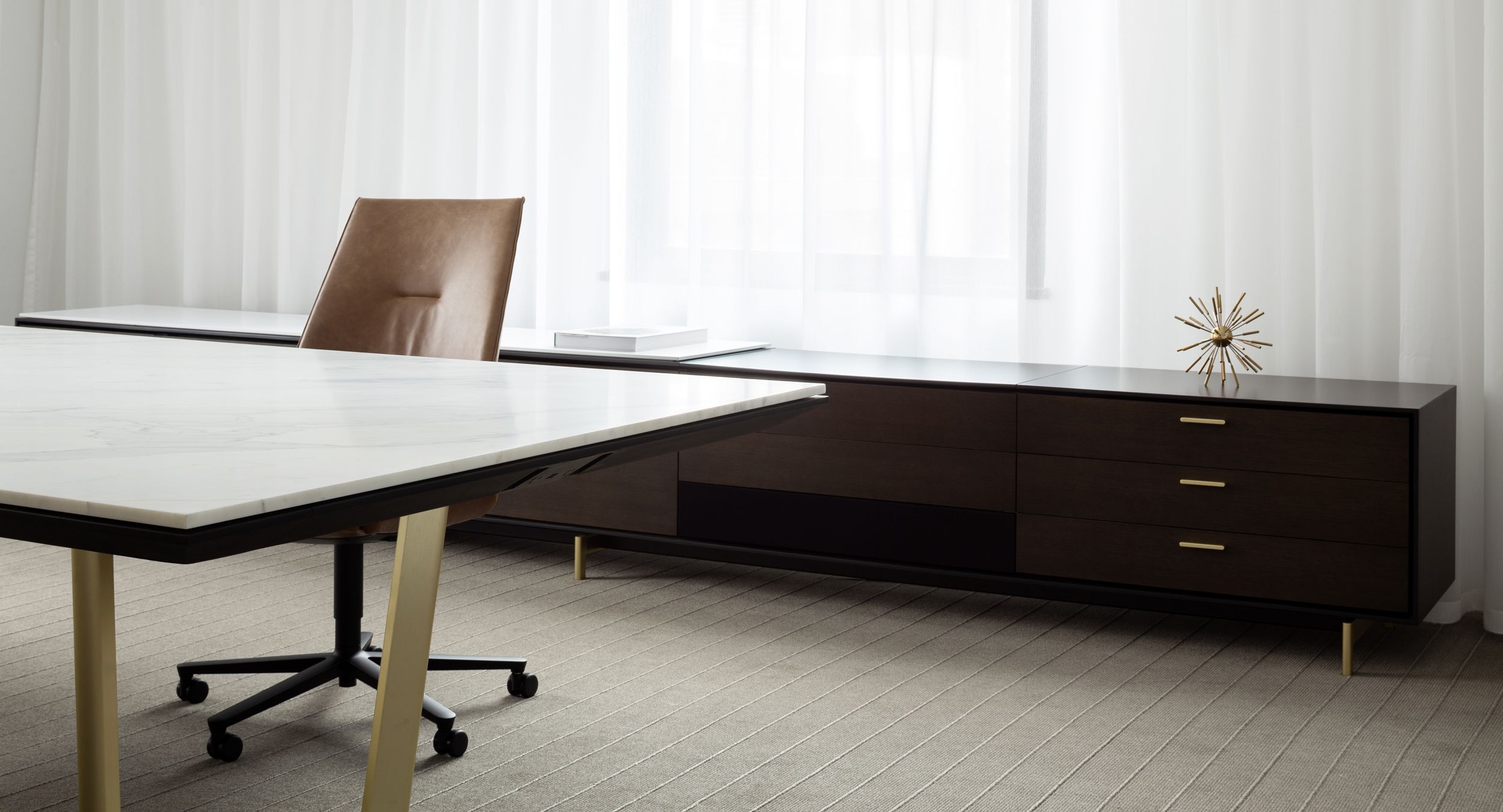 Halo table with Calacatta surface and brushed brass base is perfectly complemented by Halo sideboard in charcoal oak.