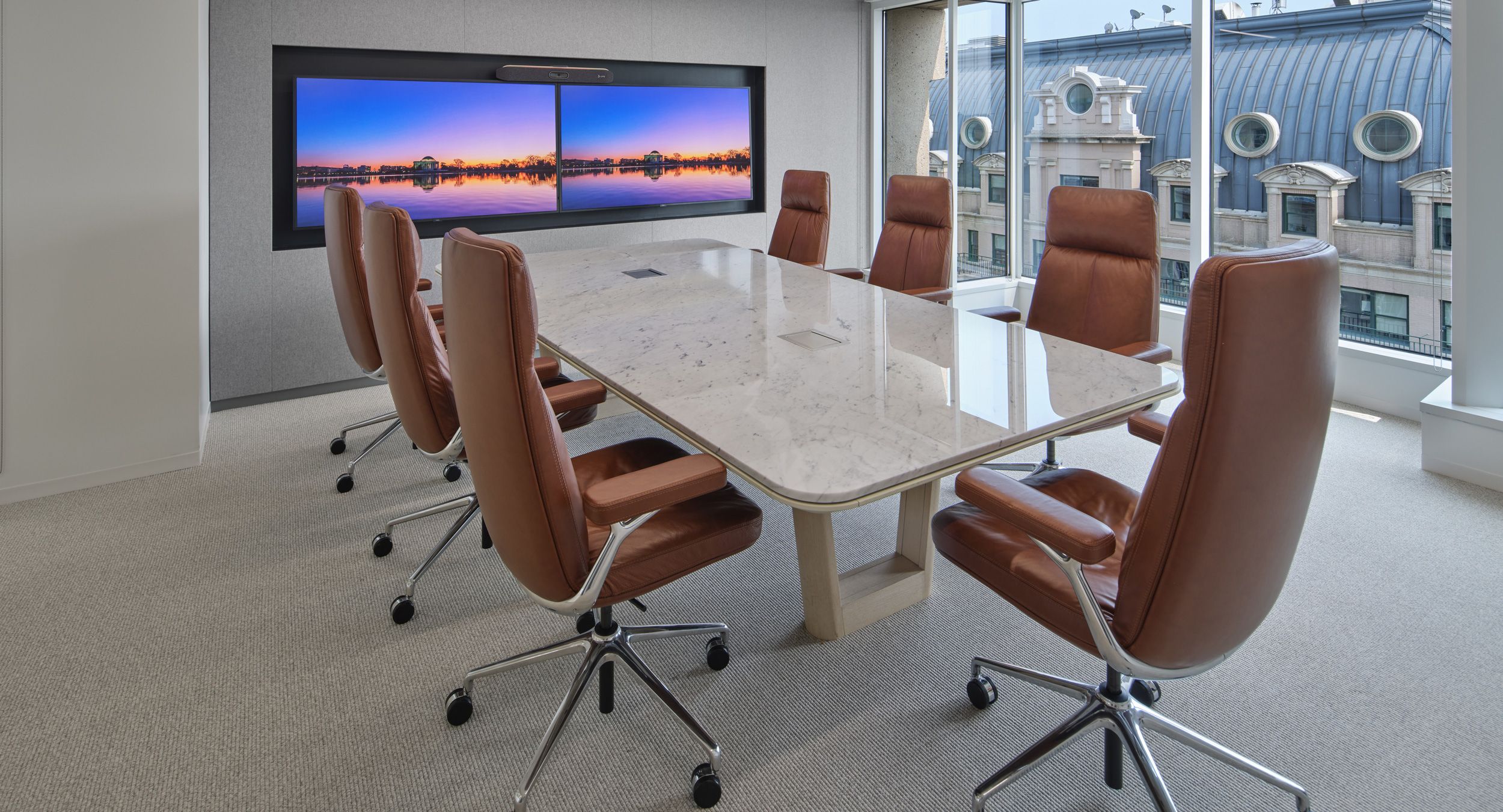 Halo open-loop, wood base conference table with with a Bianco Carrara stone surface. Halo soft edge in soft white completes the luxurious palette.