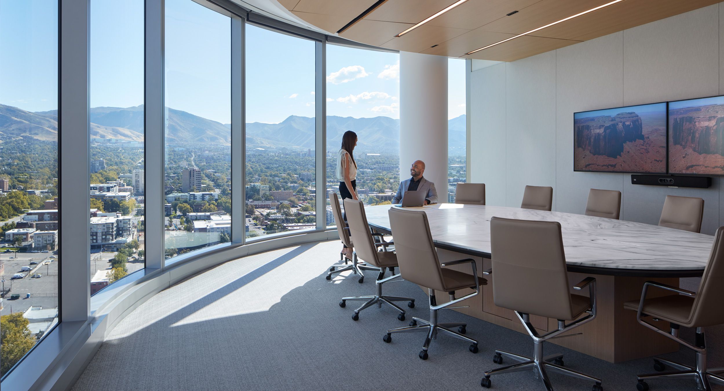 Stunning Halo conference table with Bianco Lasa stone surface, mink Halo soft-edge and custom finish continuous base.