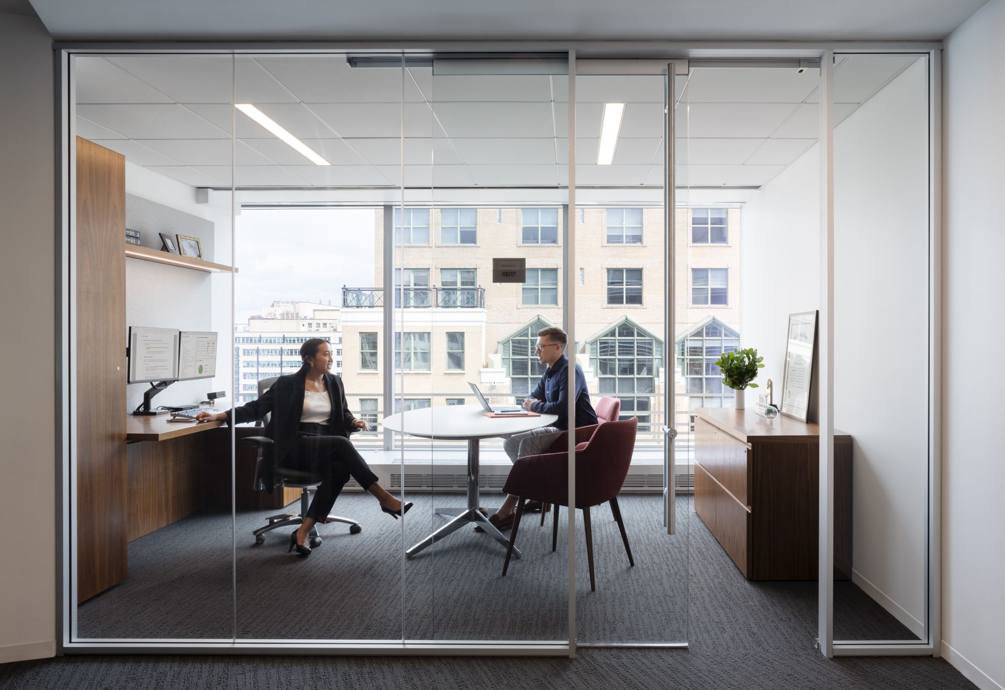 New Millennia private office in figured walnut with an adjustable-height work surface. A matching credenza and Sessions meeting table with polished chrome base complete this elegant space.