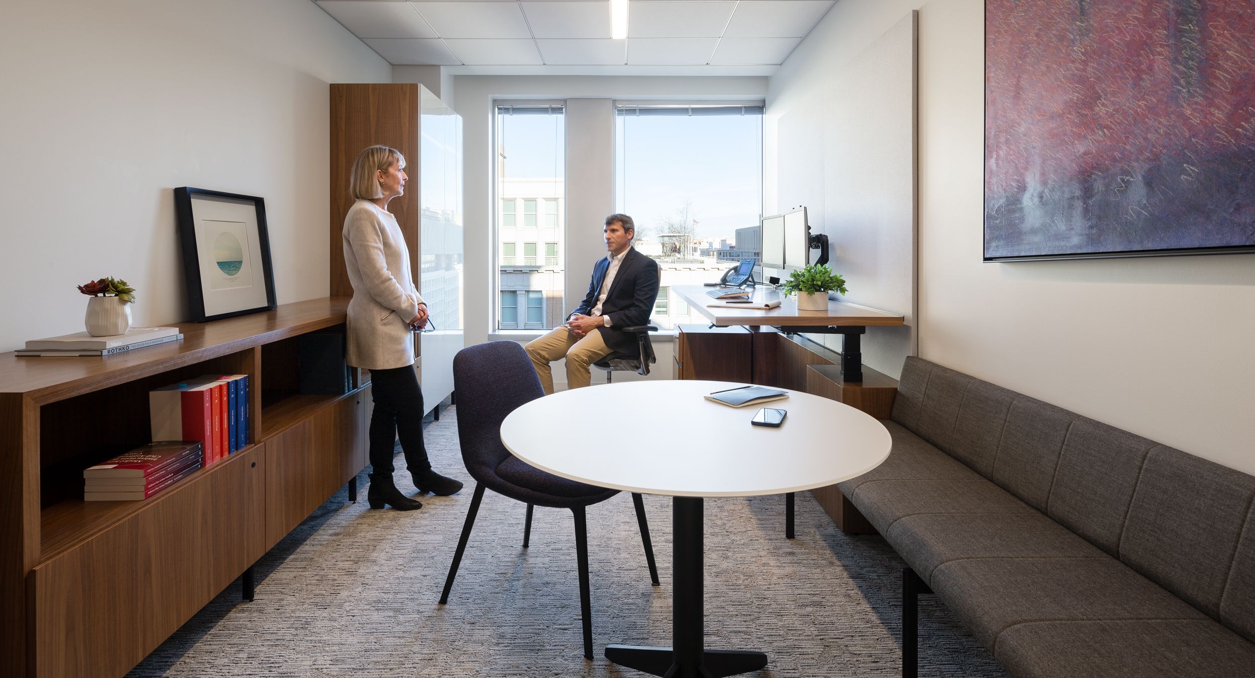 An adjustable-height New Millennia private office  is perfectly complemented by a glass surfaced Sessions table and Halo bench.