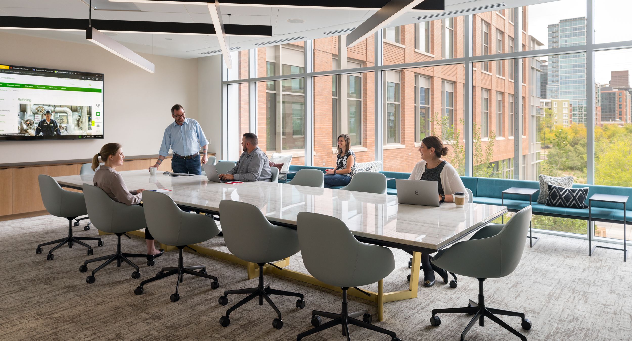 This meeting space features HALO gallery seating and a HALO table in stone and brushed brass.