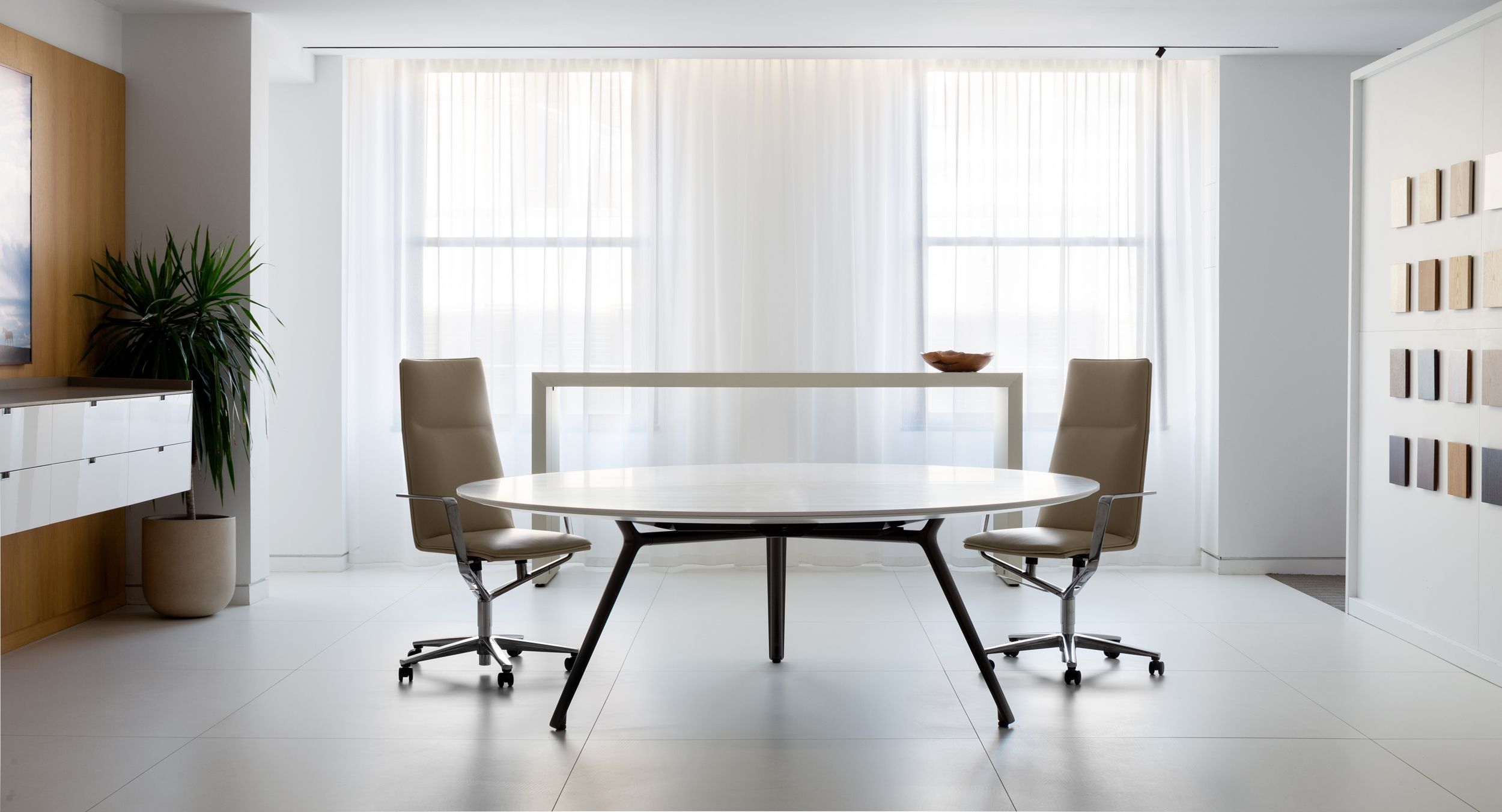 A STRATOS table in Designer White Corian and Bronze anchors the space  with a LEX floating credenza and bar-height HUGO table as perfect complements.