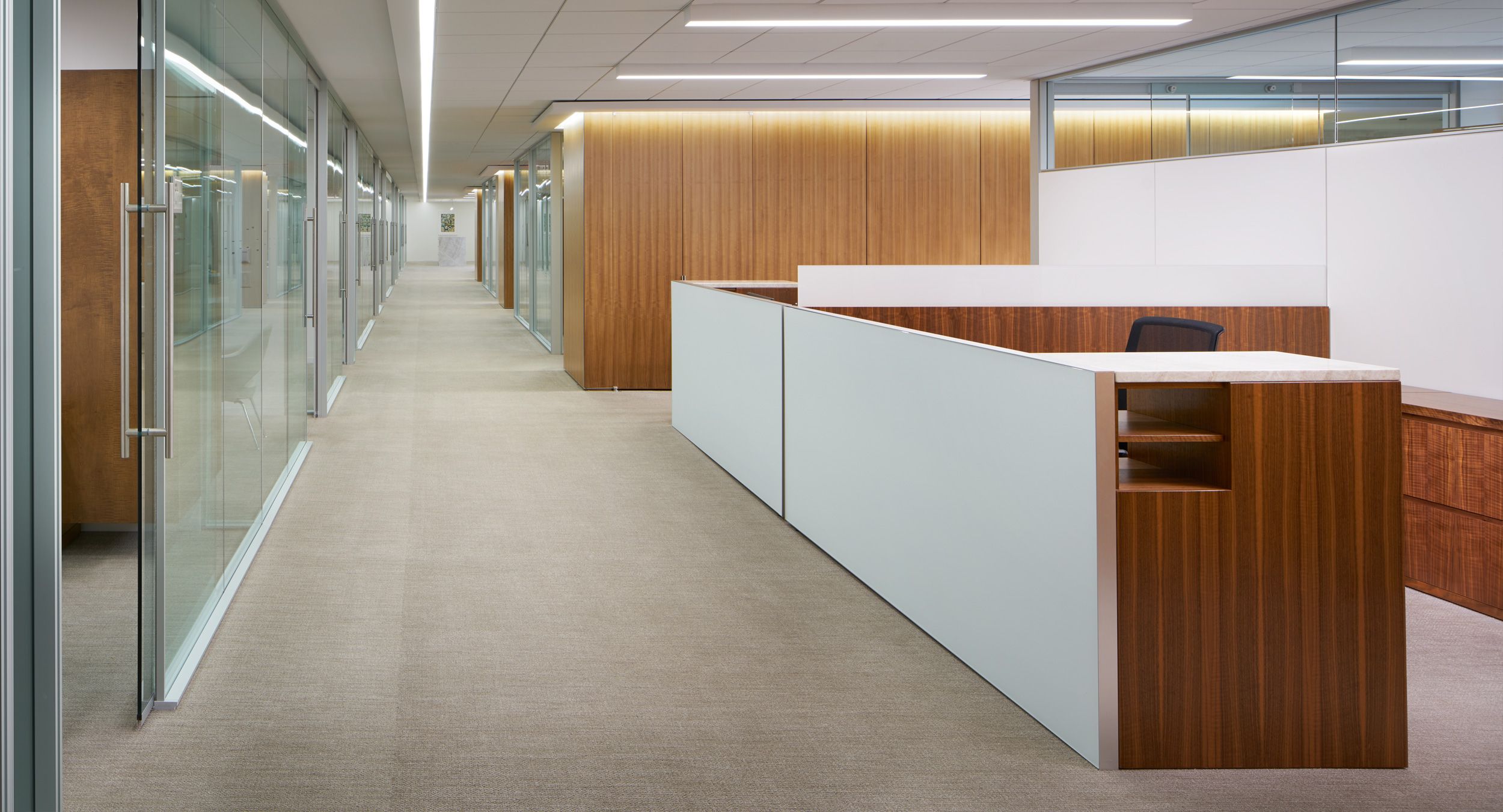 Administrative workstations feature stone, etched glass, and figured walnut veneers.