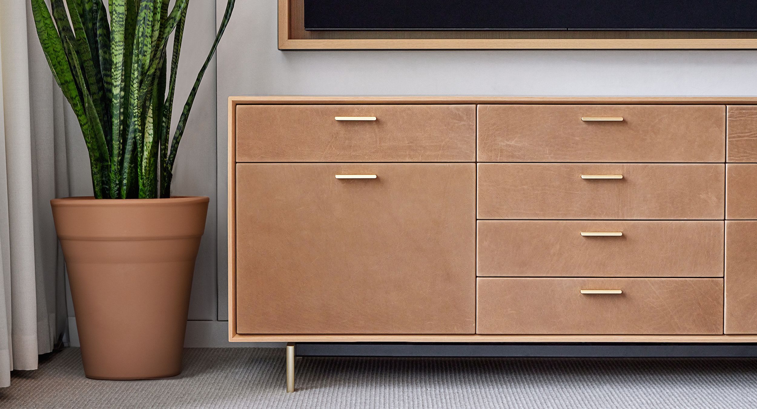 HALO credenza with brushed brass finger pulls and base with custom leather faces.