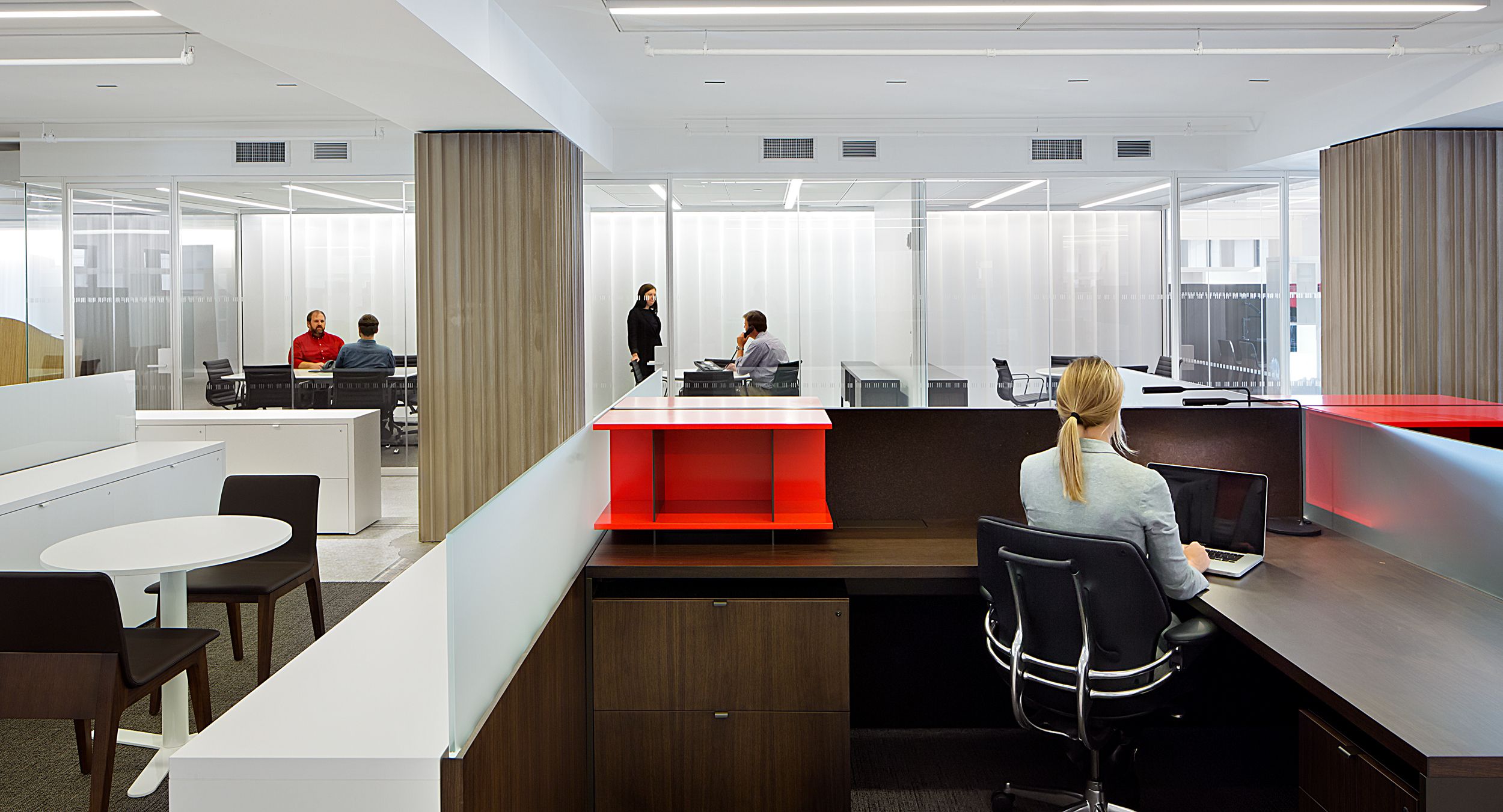 Custom-designed furniture incorporates Smoked Walnut, FilzFelt, bronze hardware, etched glass, and painted Chemcolor in White and Traffic Red.