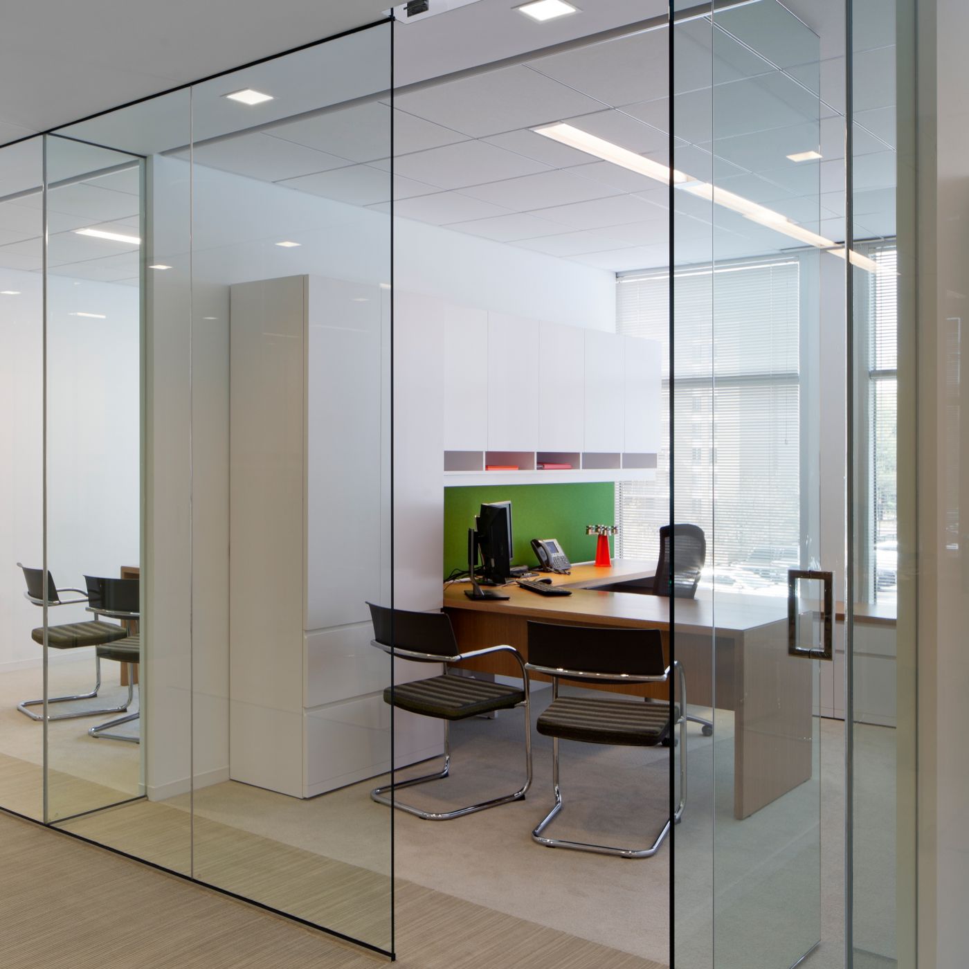 NEW MILLENNIA private offices incorporate the same materials as the open plan to unify the entire workspace; Rift White Oak, White Chemcolor, and fabric in multiple shades of green.