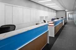 Administrative stations featured stone transaction counters, blue tinted glass, frosted acrylic privacy screen, white laminate and wood surround panels with satin aluminum base accent trim. thumbnail