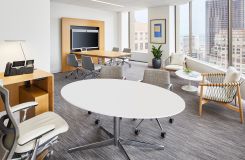 This SESSIONS elliptical table features a Modern White Corian® surface and a MESA media wall is finished in Rift White Oak and Polished Chrome. thumbnail
