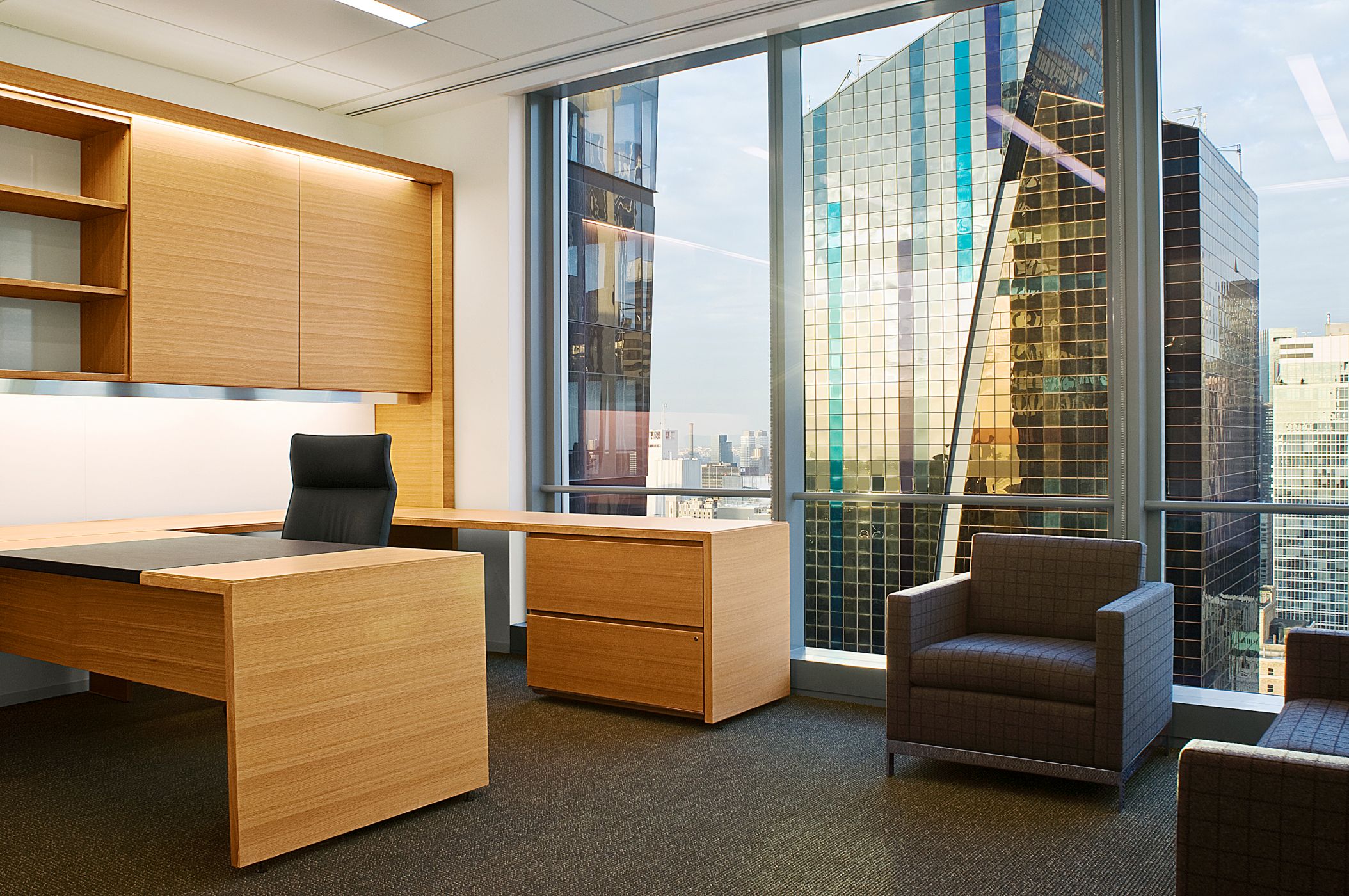 Offices incorporate cerused oak veneers, sliding doors, metal detailing, and integrated lighting. 