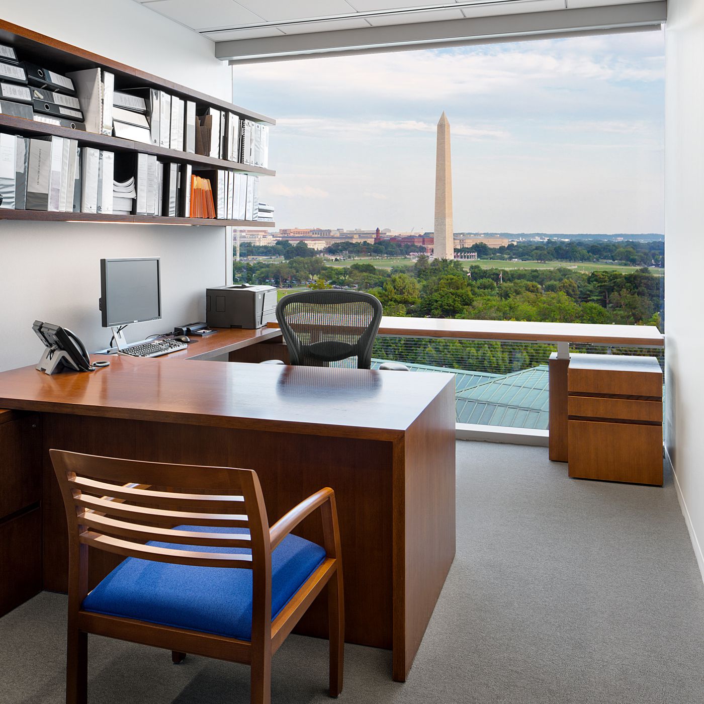 Attorney offices in Quarter Cut Elm veneer feature a height-adjustable surface at the window. 